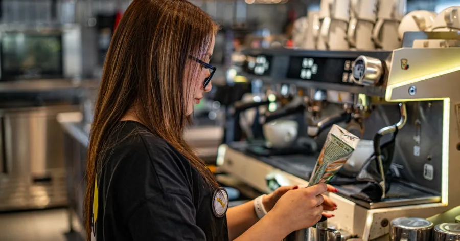 Barista kávét készít az eszpresszógépnél egy hangulatos kávézóban